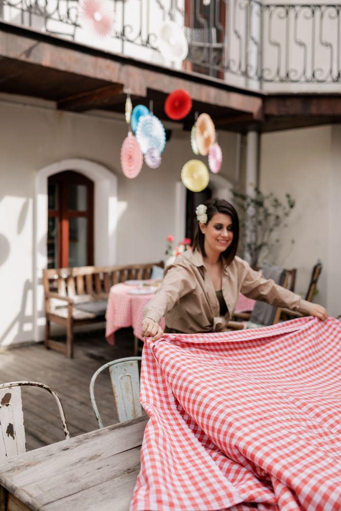 services-02 Brunette woman preparing a decorative table setting on an outdoor patio for a festive event.